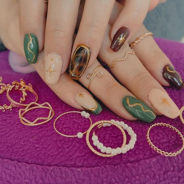 Uñas verde y vino con trazos dorados